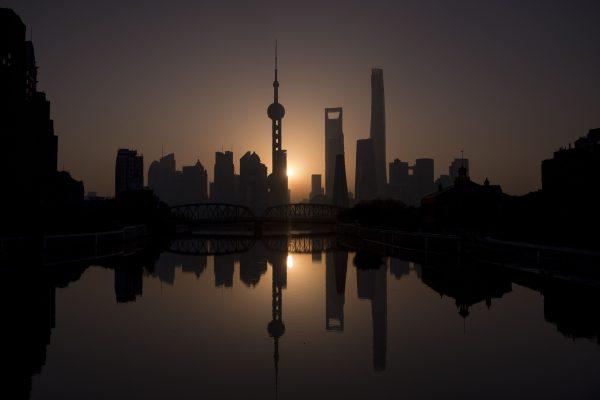 The sun rises behind the Shanghai skyline, overlooking the Pudong District on Nov. 11, 2016. (Johannes Eisele/AFP/Getty Images)