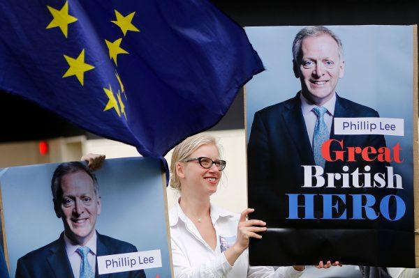 Pro-EU demonstrators hold posters of Britain's former junior Justice Minister Phillip Lee, who resigned earier today, during an anti-Brexit protest outside the Houses of Parliament in London on June 12, 2018. (Tolga Akmen/AFP/Getty Images)