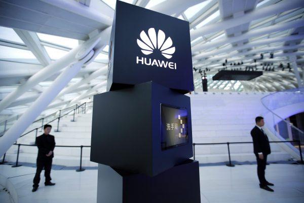 Security personnel near a pillar with the Huawei logo at a launch event for the Huawei MateBook in Beijing. (Mark Schiefelbein/AP/File Photo)