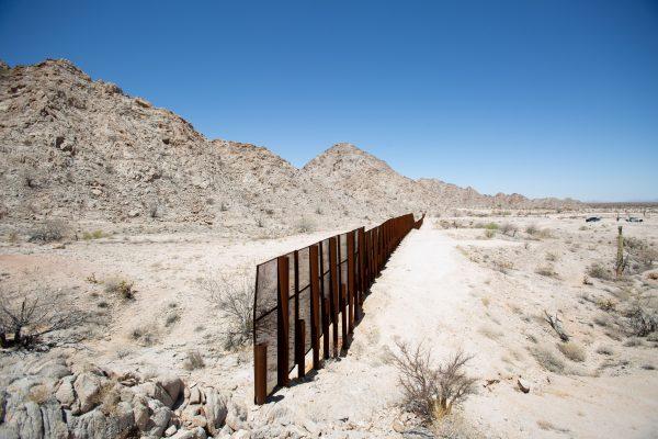 The U.S.-Mexico border where the fence ends on the side of a rocky mountain in the desert near Yuma, Ariz., on May 25, 2018. Mexico is on the left side of the fence. (Samira Bouaou/The Epoch Times)