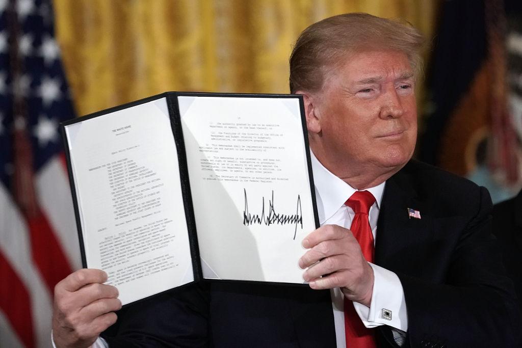President Donald Trump holds up an executive order that he signed during a meeting of the National Space Council at the East Room of the White House in Washington on June 18, 2018. (Alex Wong/Getty Images)