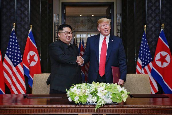 In this handout photograph provided by The Strait Times, North Korean leader Kim Jong-un (L) with U.S. President Donald Trump (R) during their historic U.S.–DPRK summit at the Capella Hotel on Sentosa island, Singapore on June 12, 2018. (Kevin Lim/The Strait Times/Handout/Getty Images)