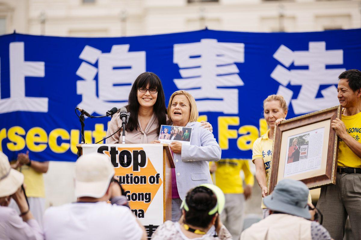 Rep. Ileana Ros-Lehtinen (R-Fla.) (2nd L) receives photos from practitioners in recognition of her support for Falun Gong over the years, at a rally calling for an end to the persecution of Falun Gong in China, on Capitol Hill in Washington on June 20, 2018. (Edward Dye/The Epoch Times)