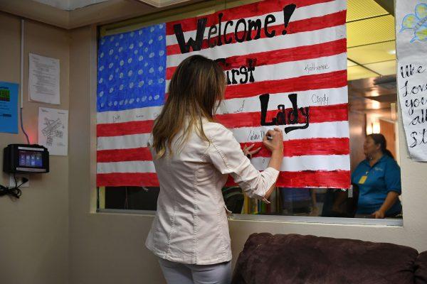 First Lady Melania Trump signs an illustration of the American flag during a visit to Upbring New Hope Children's Center in McAllen, Texas, on June 21, 2018. (MANDEL NGAN/AFP/Getty Images)