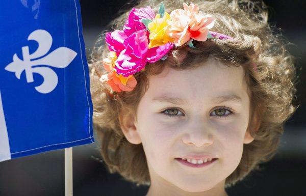 A young girl holds a Quebec flag during the annual Saint-Jean-Baptiste Day parade in Montreal on June 24, 2017. (The Canadian Press/Graham Hughes)