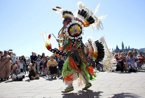 A traditional dance is performed on National Indigenous Peoples Day behind the Canadian Museum of History in Gatineau, Que., on June 21, 2018. (The Canadian Press/David Kawai)