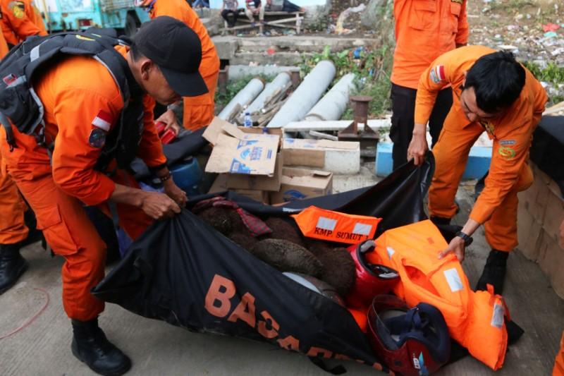 Search and rescue officers carry items they believe belonged to passengers from a ferry which sank last week in Lake Toba, at Tigaras Port, Simalungun, North Sumatra, Indonesia June 25, 2018 in this photo taken by Antara Foto. Picture taken June 25, 2018. (Irsan Mulyadi/Antara Foto via Reuters)