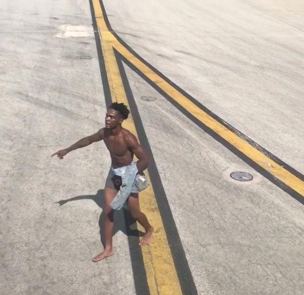A man in underpants gestures as he walks to a plane on the tarmac at the airport in Atlanta, Georgia, U.S., June 26, 2018 in this picture obtained from social media. (TK James via Reuters)