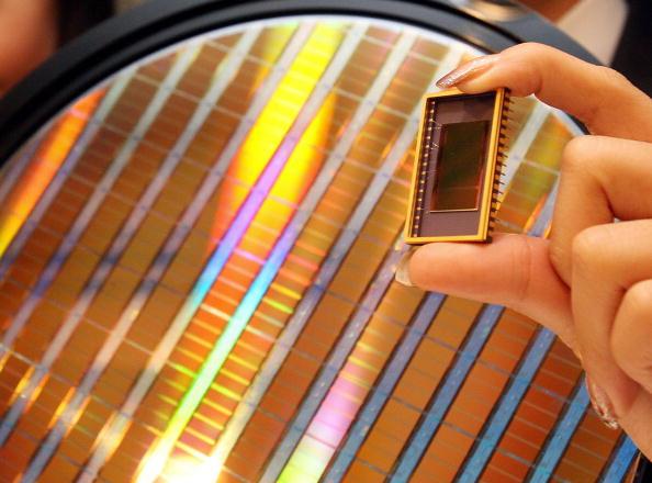 An employee of Samsung Electronics shows the world's first 30-nanometer 64-gigabit NAND flash memory device during a news conference in Seoul, on October 23, 2007. (Kim Jae-hwan/AFP/Getty Images)