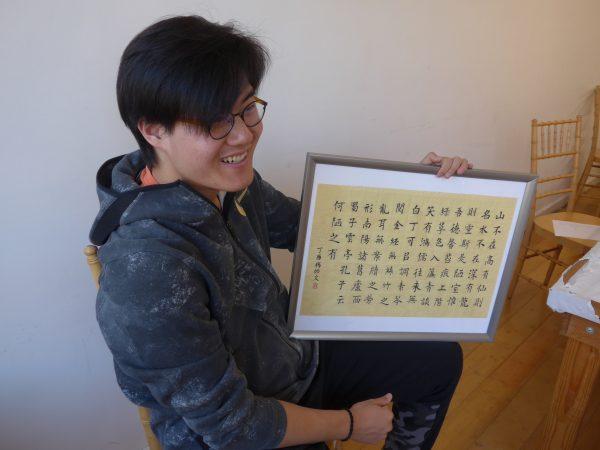Tony Yang, an 11th grader at Xian Yun Academy of the Arts, talks about the process of creating his calligraphy art work and what he learned from it. (Cornelia Ritter/Xian Yun Academy)
