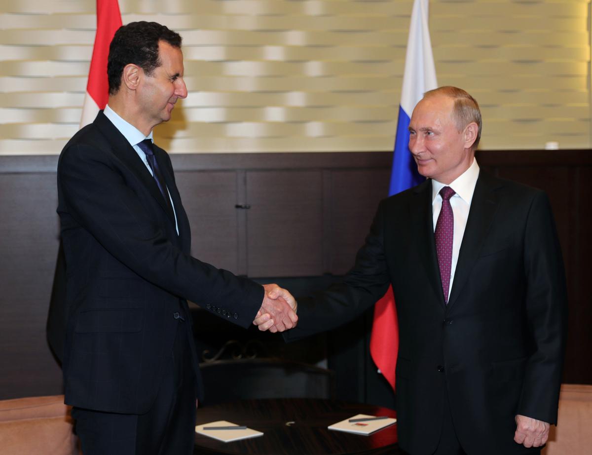 Russian President Vladimir Putin (R) shakes hands with his Syrian counterpart Bashar al-Assad during their meeting in Sochi on May 17, 2018. (Mikhail Klimentyev/AFP/Getty Images)