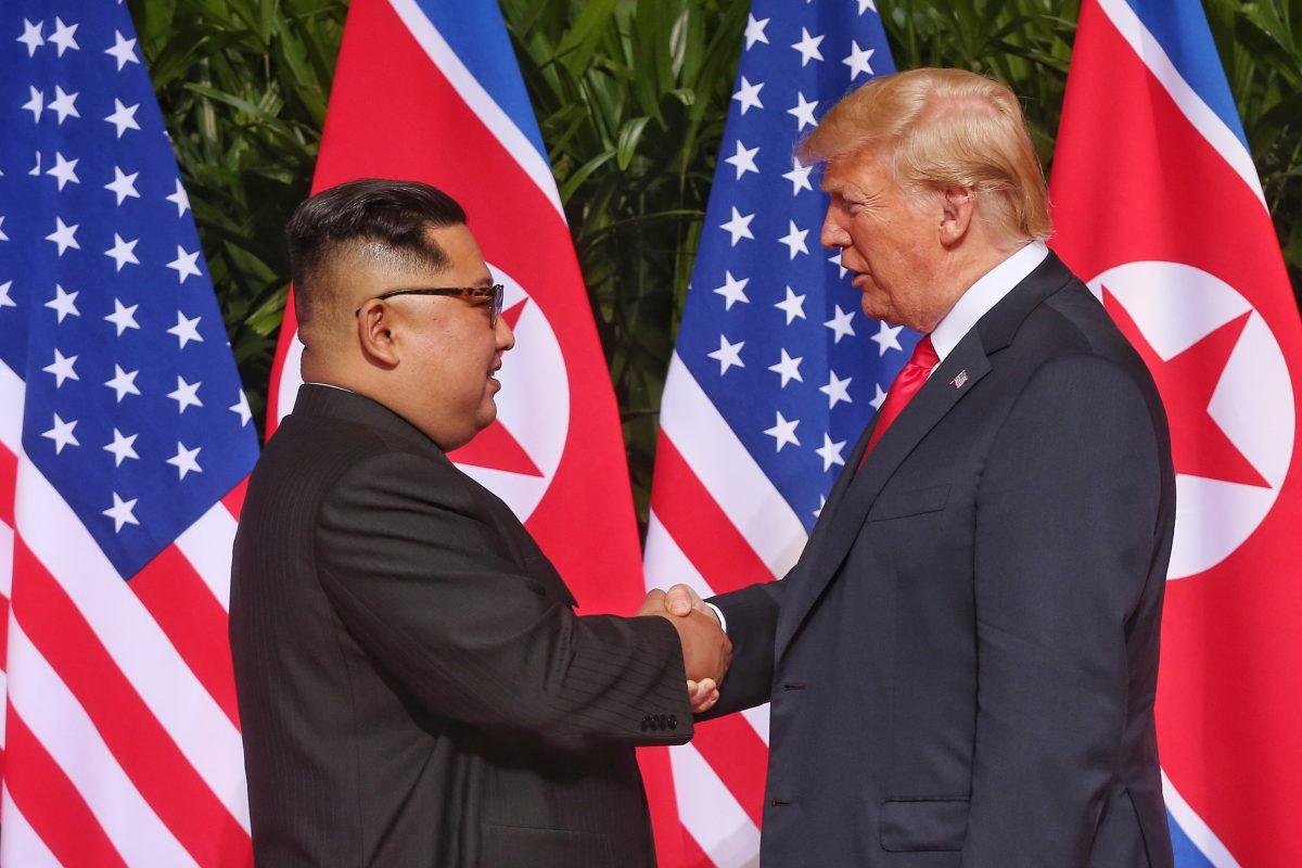 In this handout photo, North Korean leader Kim Jong-un (L) shakes hands with U.S. President Donald Trump during their historic U.S.-DPRK summit at the Capella Hotel on Sentosa island on June 12, 2018 in Singapore. (Photo by Handout/Getty Images)