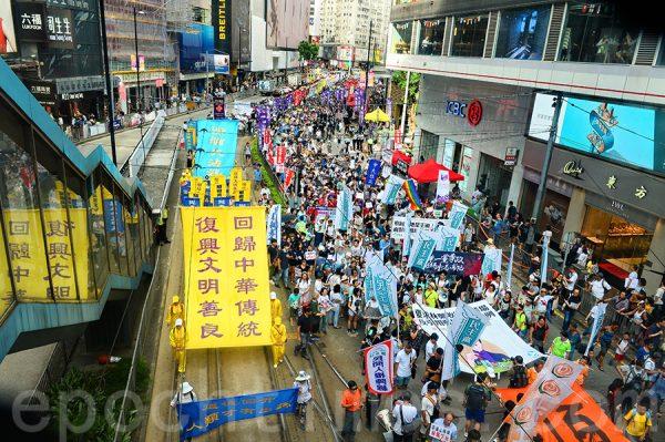 Falun Gong adherents hold up a giant yellow banner calling on the restoration of traditional Chinese culture in China in Hong Kong on July 1, 2018. (Song Bilong/The Epoch Times)