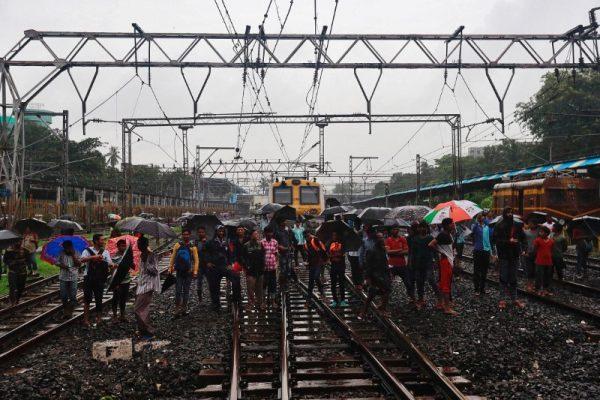 Commuters watch the rescue work at the site of an overbridge that collapsed over the railway tracks after heavy rains in Mumbai, India on July 3, 2018. (REUTERS/Danish Siddiqui)