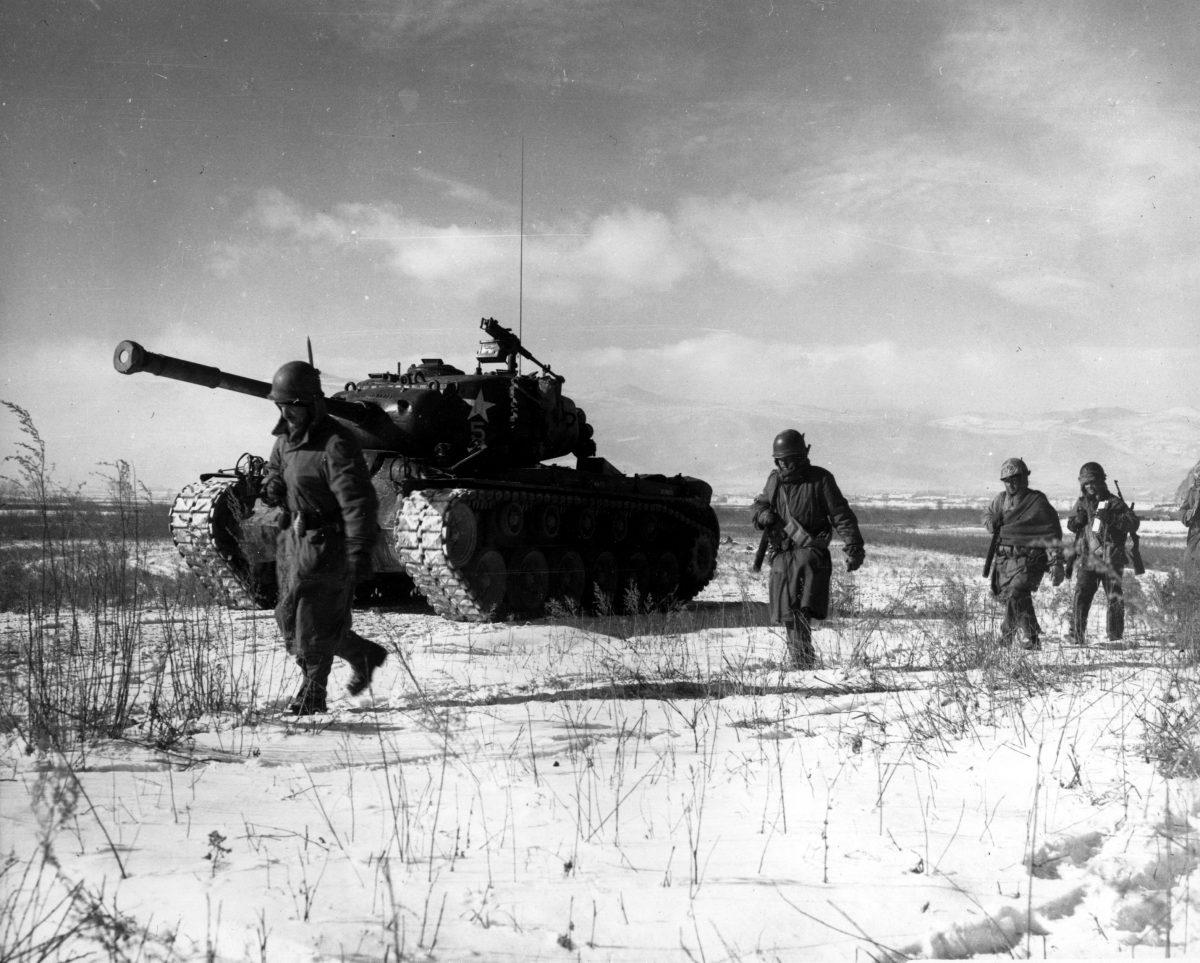 A column of troops and armor of the U.S. 1st Marine Division move through communist Chinese lines during their successful breakout from the Chosin Reservoir in North Korea during the Korean War. (Cpl. Peter McDonald, U.S. Marine Corps)