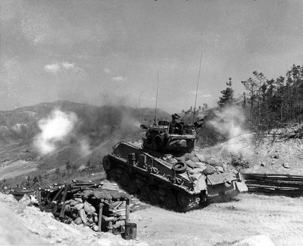 A column of troops and armor of the 1st Marine Division move through communist Chinese lines during their successful breakout from the Chosin Reservoir in North Korea during the Korean War. (Cpl. Peter McDonald, US Marine Corps)