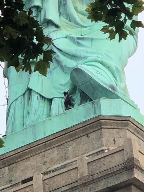 A protester is seen on the Statue of Liberty in New York, New York on July 4, 2018. (Danny Owens/Reuters)