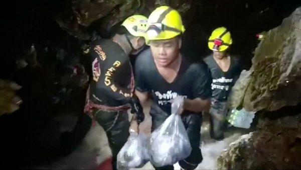 Rescuers carry supplies into the Tham Luang cave complex, where 12 boys and their soccer coach are trapped, in the northern province of Chiang Rai, Thailand, July 5, 2018. Video taken July 5, 2018. (RUAMKATANYU FOUNDATION/Handout via Reuters TV)