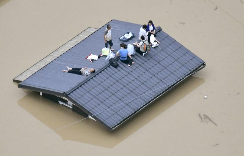 An aerial view shows local residents seen on the roof of submerged house at a flooded area as they wait for a rescue in Kurashiki, southern Japan, in this photo taken by Kyodo July 7, 2018. (Kyodo/Reuters)