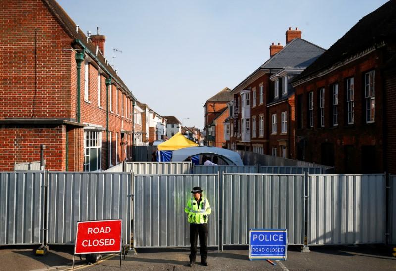 A police officer stands in front of screening erected behind John Baker House, after it was confirmed that two people had been poisoned with the nerve-agent Novichok, in Amesbury, Britain, July 5, 2018. (Henry Nicholls/Reuters)