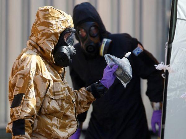 Forensic investigators, wearing protective suits, emerge from the rear of John Baker House, after it was confirmed that two people had been poisoned with the nerve-agent Novichok, in Amesbury, Britain, July 6, 2018. (Henry Nicholls/Reuters)