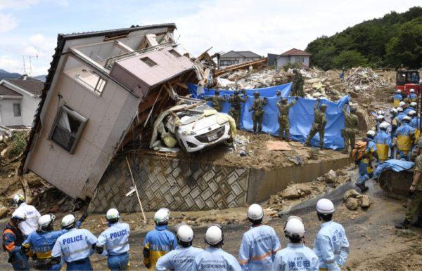 Rescue workers look for missing people in a house damaged by heavy rain in Kumano town, Hiroshima Prefecture, Japan, in this photo taken by Kyodo July 9, 2018. (Kyodo/via Reuters)