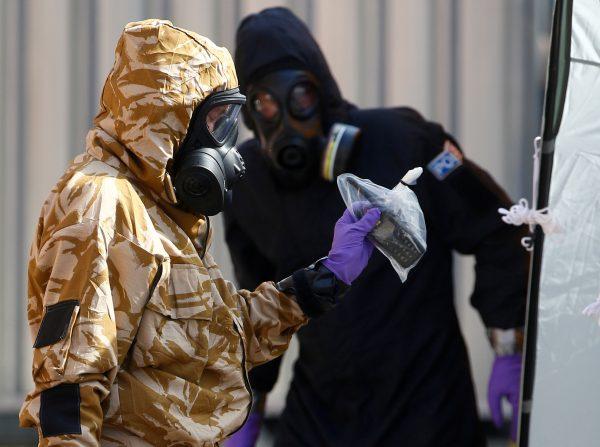 Forensic investigators wearing protective suits emerge from the rear of John Baker House in Amesbury, United Kingdom, on July 6, 2018. (Henry Nicholls/Reuters, File Photo)