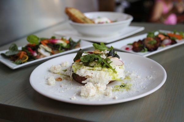 Baked heirloom cornmeal polenta with a fried egg, creamy ricotta, pea greens, and pumpkin seed pesto from Nicks on Broadway. (Channaly Philipp/The Epoch Times)