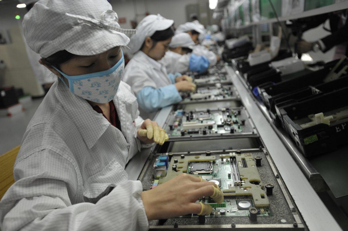 In this file photo, Chinese workers are shown in a Foxconn factory in Shenzhen, in southern China's Guangdong Province. U.S. tariffs on goods exported from China could potentially harm this Taiwanese company. (STR/AFP/GettyImages)