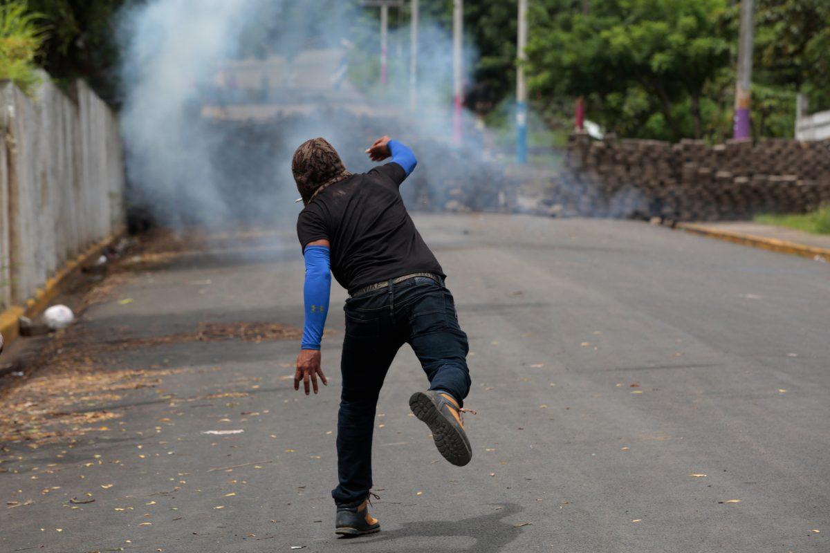 A demonstrator throws a homemade device during the funeral service of Jose Esteban Sevilla Medina, who died during clashes with pro-government supporters in Monimbo, Nicaragua July 16, 2018. (Reuters/Oswaldo Rivas)