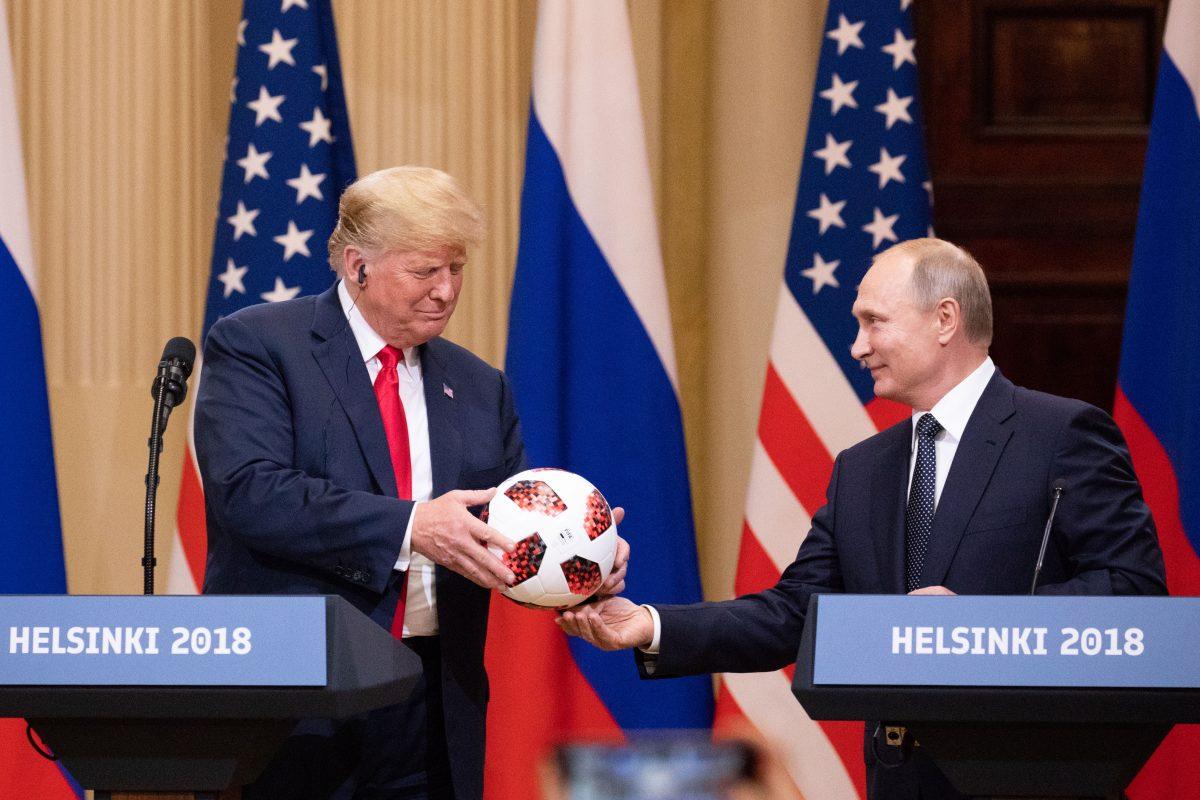 Russian President Vladimir Putin presents President Donald Trump with a soccer ball during a joint press conference at the Presidential Palace in Helsinki, on June 16, 2018. (Samira Bouaou/The Epoch Times)