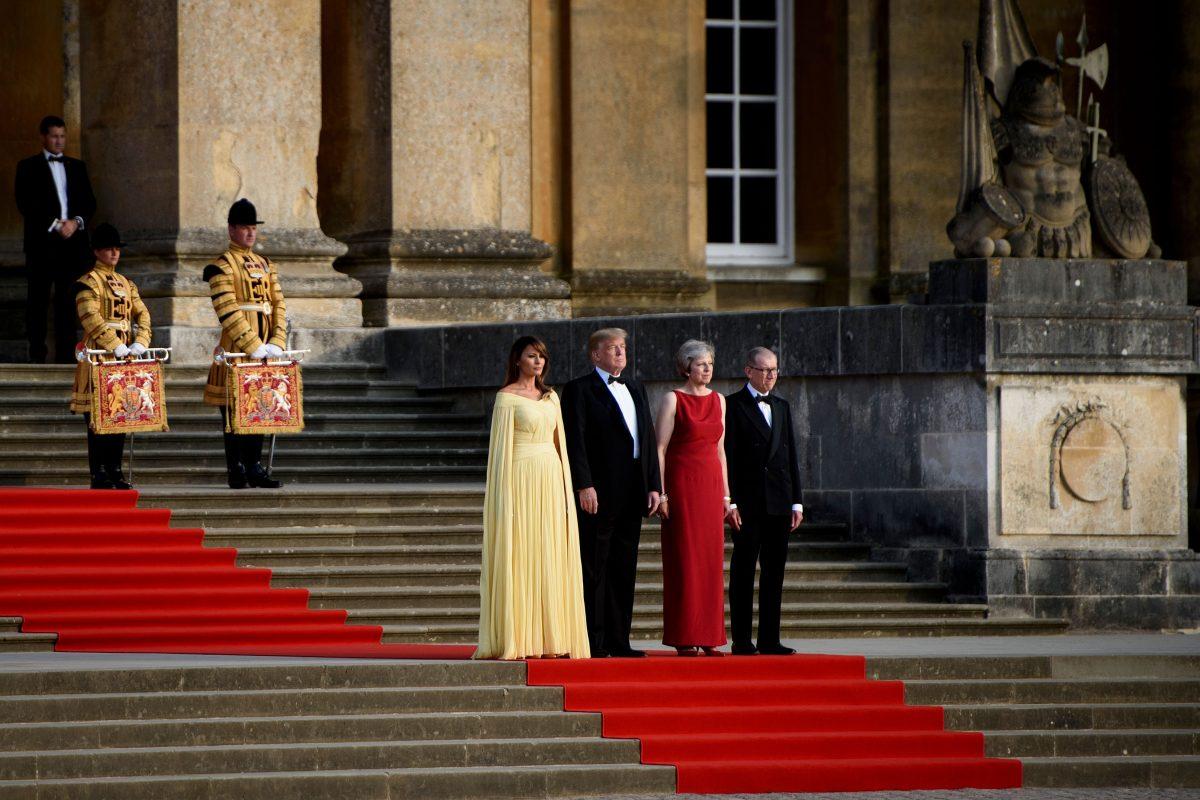 First Lady Melania Trump, President Donald Trump, UK Prime Minister Theresa May, and her husband Philip May stand on the steps in the Great Court to watch the bands of the Scots, Irish, and Welsh Guards perform a ceremonial welcome at Blenheim Palace, west of London, on July 12, 2018. (BRENDAN SMIALOWSKI/AFP/Getty Images)