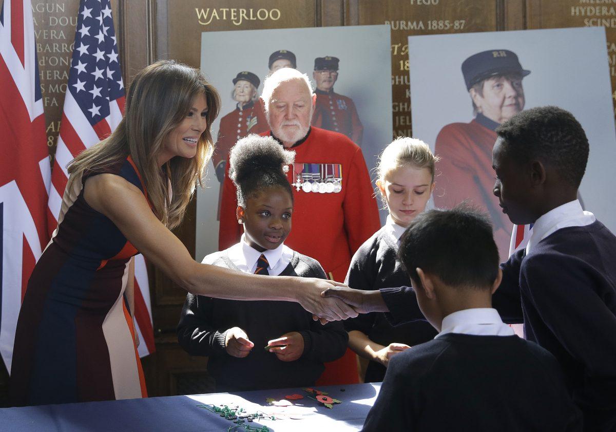 First Lady Melania Trump shakes hands with a schoolboy as she helps children to make poppies during a visit with British military veterans, at Royal Hospital Chelsea in London on July 13, 2018. (Luca Bruno–WPA Pool/Getty Images)