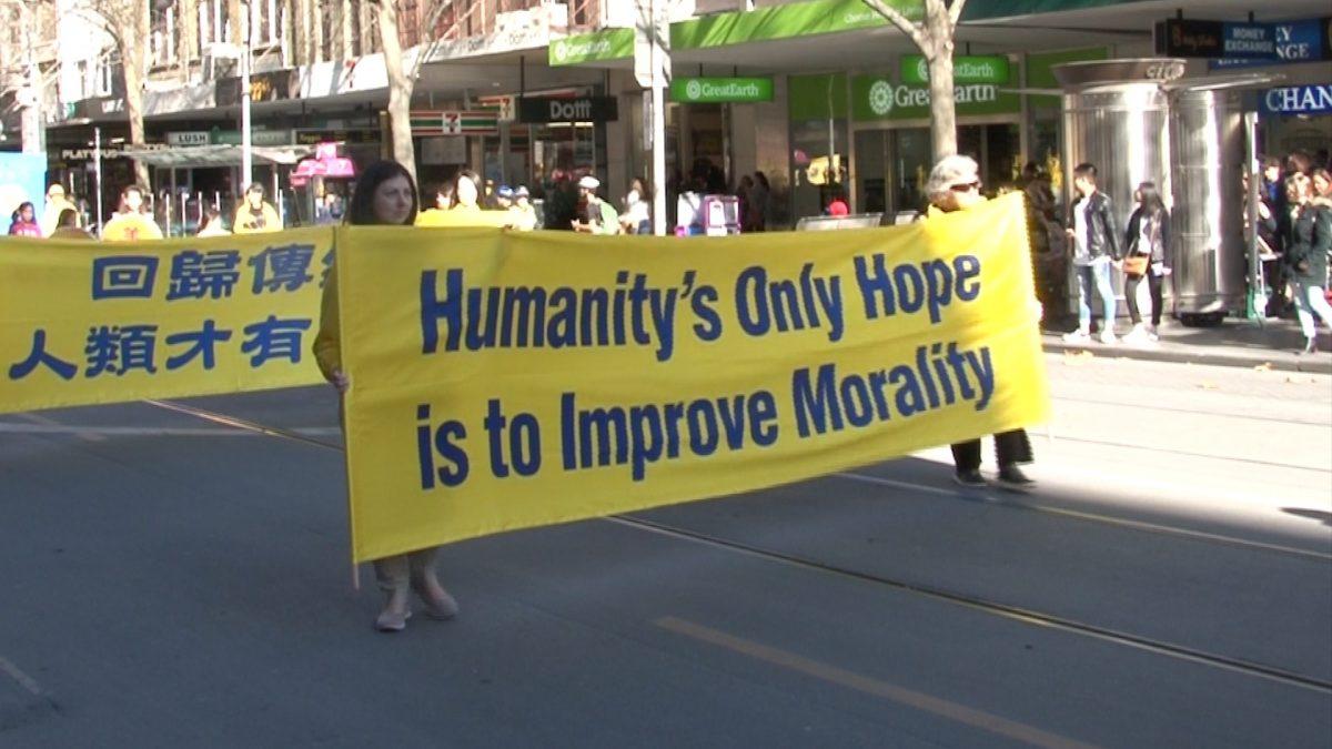 Falun Dafa practitioners in Melbourne holding a banner that reads "Humanity's only hope is to improve morality," during a rally marking 19 years of persecution in China. (Henry Jom/The Epoch Times)