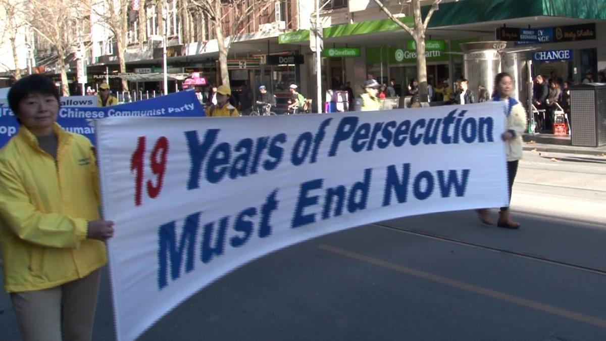Falun Dafa practitioners in Melbourne holding a banner that reads "19 years of persecution must end now," during a rally marking 19 years of persecution in China. (Henry Jom/The Epoch Times)