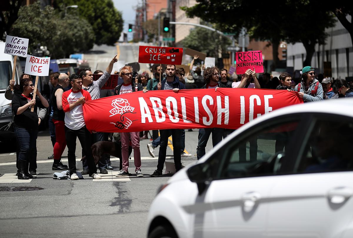 Protesters hold signs as they block a street during a demonstration outside the San Francisco office of Immigration and Customs Enforcement on June 19, 2018. (Justin Sullivan/Getty Images)