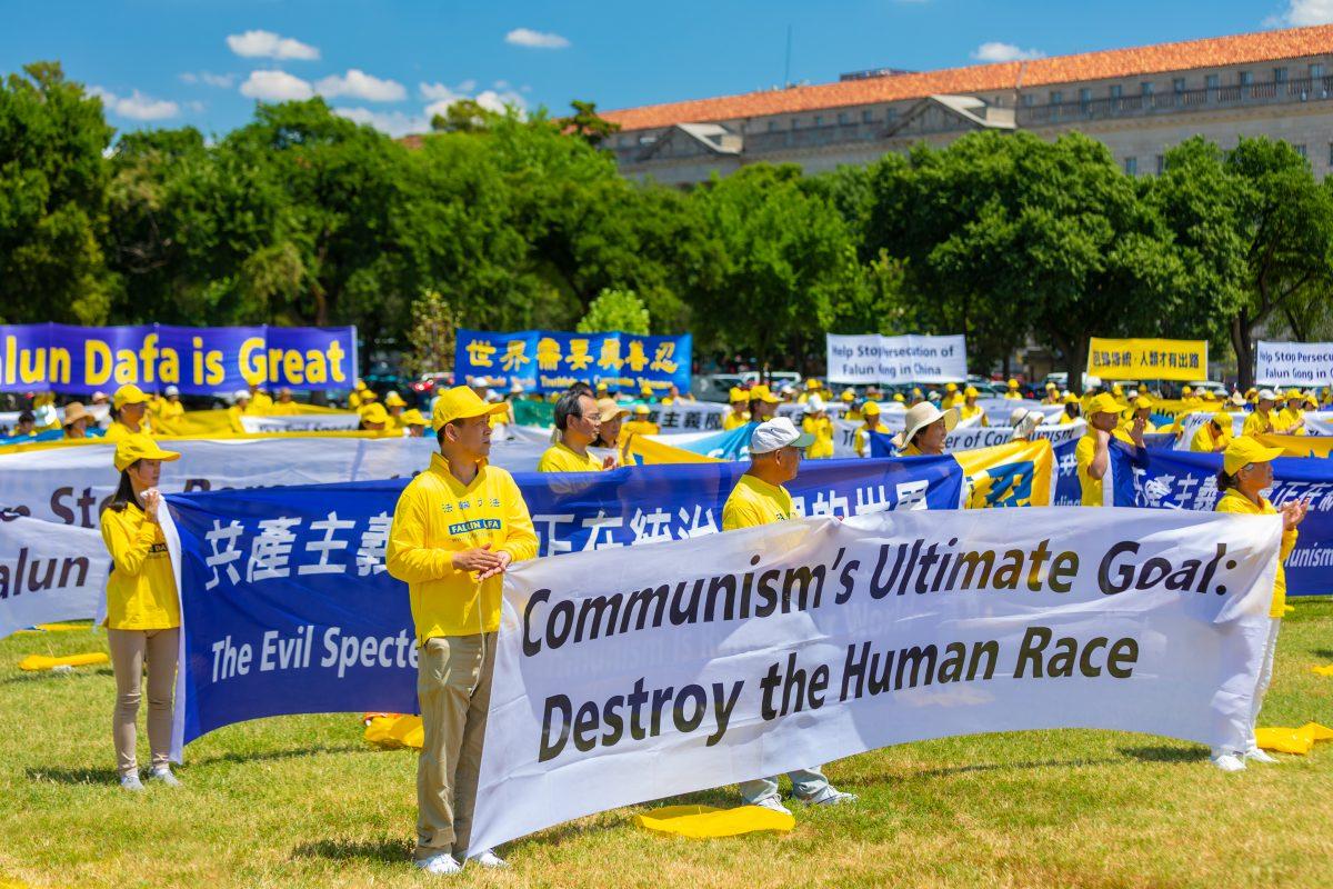 Falun Gong practitioners hold banners at a rally calling for an end to the persecution of Falun Gong, at the Washington Monument on July 19, 2018. (Mark Zou/Epoch Times)