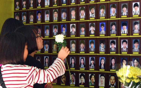 Visitors pray in front of portraits of victims of the 2014 South Korea's Sewol ferry disaster at a memorial altar in Seoul on May 25, 2017. (Jung Yeon-Je/AFP/Getty Images)