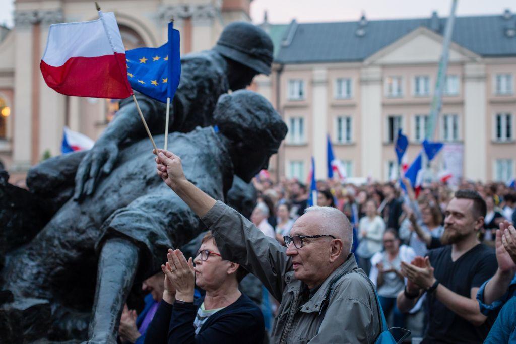 Protesters hold Polish and EU flags as they take part in demonstration in front of Polish Supreme Court on July 21, 2017, in protest against new bill changing the judiciary system. (Wojtek Radwanski/AFP/Getty Images)
