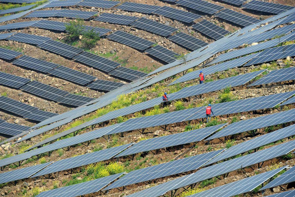 Chinese workers check solar photovoltaic modules on a hillside in a village in Chuzhou, in eastern China's Anhui Province on April 13, 2017. (STR/AFP/Getty Images)