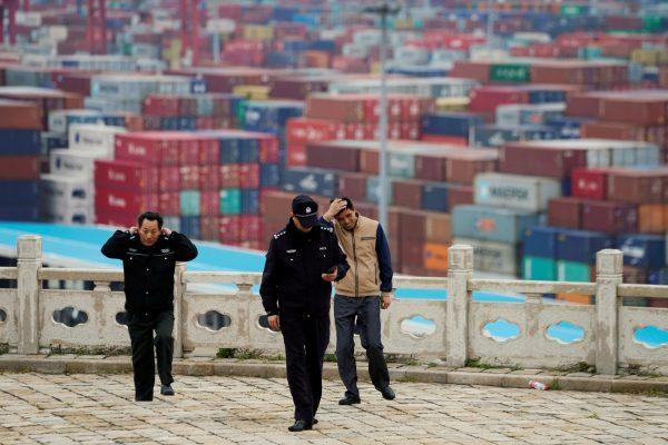 Security guards walk in front of containers at the Yangshan Deep Water Port in Shanghai, China on April 24, 2018. (Aly Song/File Photo/Reuters)