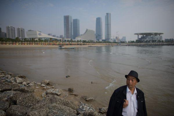 A man stands before the skyline of Xiamen City, Fujian Province, on Oct. 25, 2013. (Ed Jones/AFP/Getty Images)