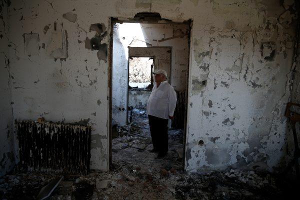 Athanassios Gantonas, stands inside his burnt house following a wildfire in the village of Mati, near Athens, Greece, July 27, 2018. (Reuters/Costas Baltas)