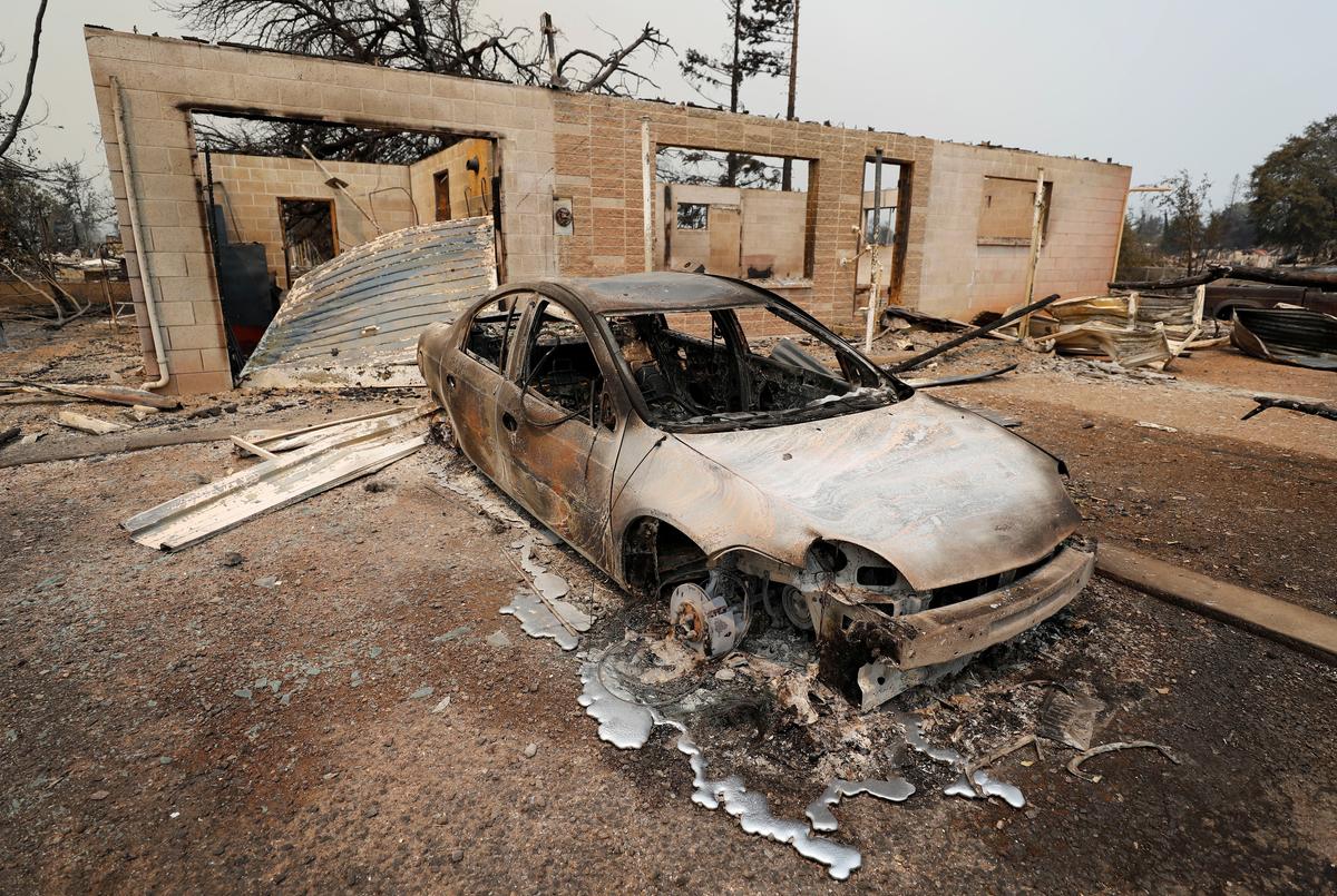 A scorched car sits next to a house that burned in the Carr Fire, west of Redding, California, U.S. July 27, 2018. (REUTERS/Fred Greaves)