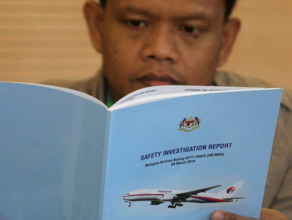 A family member reads an MH370 briefing report before a closed door meeting in Putrajaya, Malaysia July 30, 2018. (REUTERS/Sadiq Asyraf)