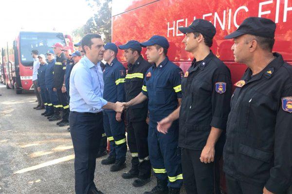 Greek Prime Minister Alexis Tsipras greets firefighters as he visits the village of Mati, following a wildfire near Athens, Greece, July 30, 2018. (Greek Prime Minister's Press Office/Handout via Reuters)