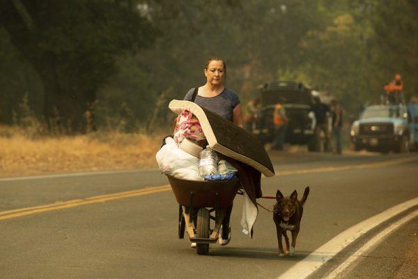 A woman, who declined to give her name, evacuates from Lakeport, Calif., as the River Fire approaches, on July 31, 2018. (AP Photo/Noah Berger)