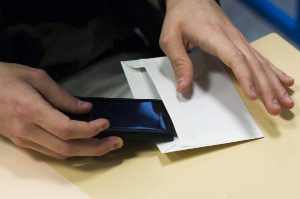 A French student puts his smartphone in an envelope to give to supervisors before an exam at the Arago high school in Paris, in this file photo. (Fred Dufour/AFP/Getty Images)
