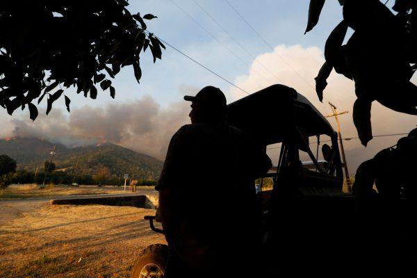 A resident watches as a plume of smoke grows from the Ranch Fire (Mendocino Complex) in the hills north of Upper Lake, California, U.S. Aug. 1, 2018. (Reuters/Fred Greaves)