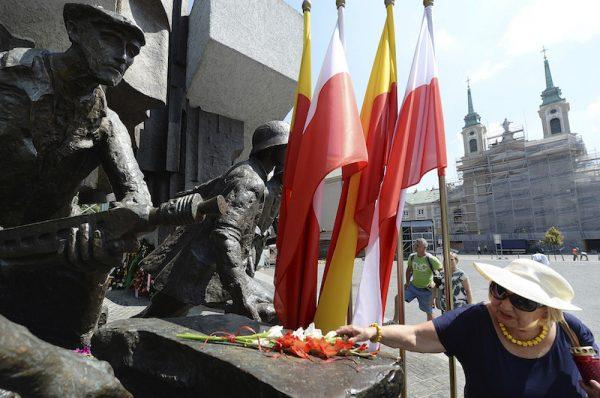 Warsaw residents lay flowers at the monument to the 1944 Warsaw Rising against the occupying Nazis to honor some 18,000 resistance fighters who fell in the struggle against the German forces and some 180,000 civilians who perished 74 years ago, in Warsaw, Poland, on Aug. 1, 2018.(AP Photo/Czarek Sokolowski)